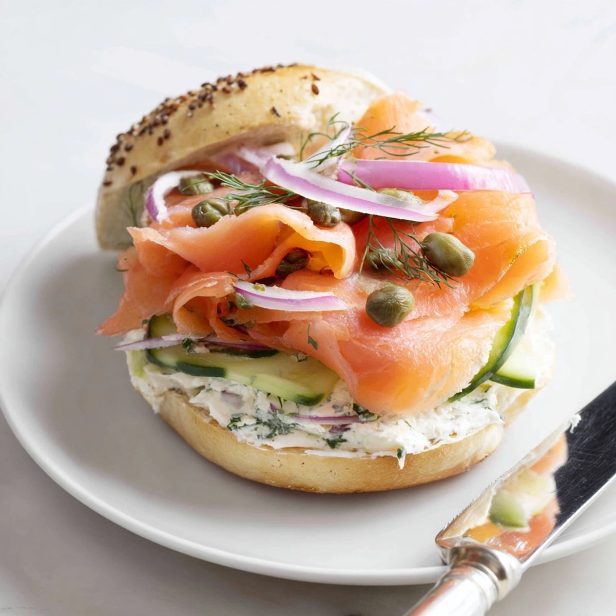 Layered Smoked Salmon & Dill Bagel Sandwiches, with creamy cheese, cucumber, and capers piled high.