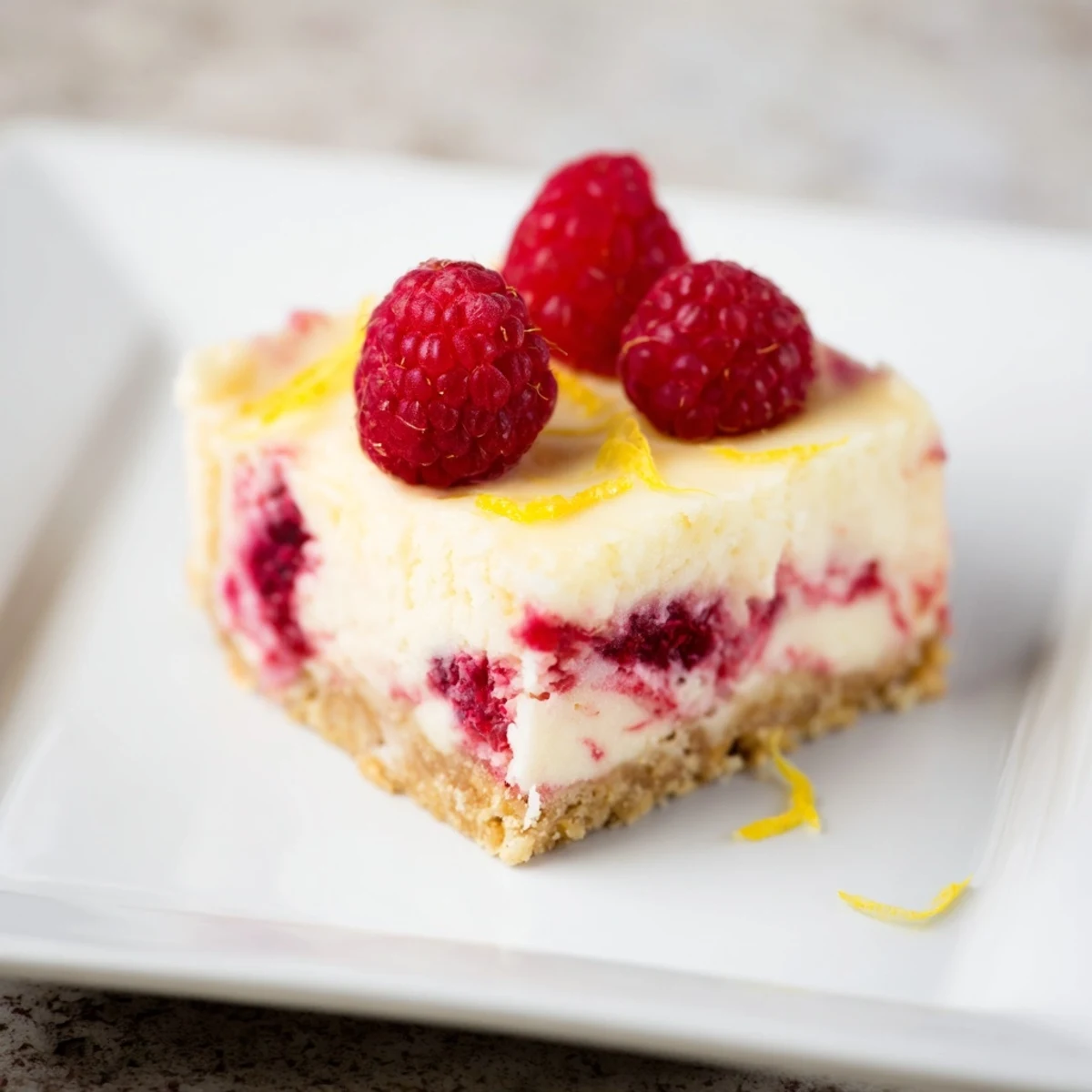 Golden, baked Lemon Raspberry Cheesecake Bars, a delightful dessert with a buttery graham cracker crust.