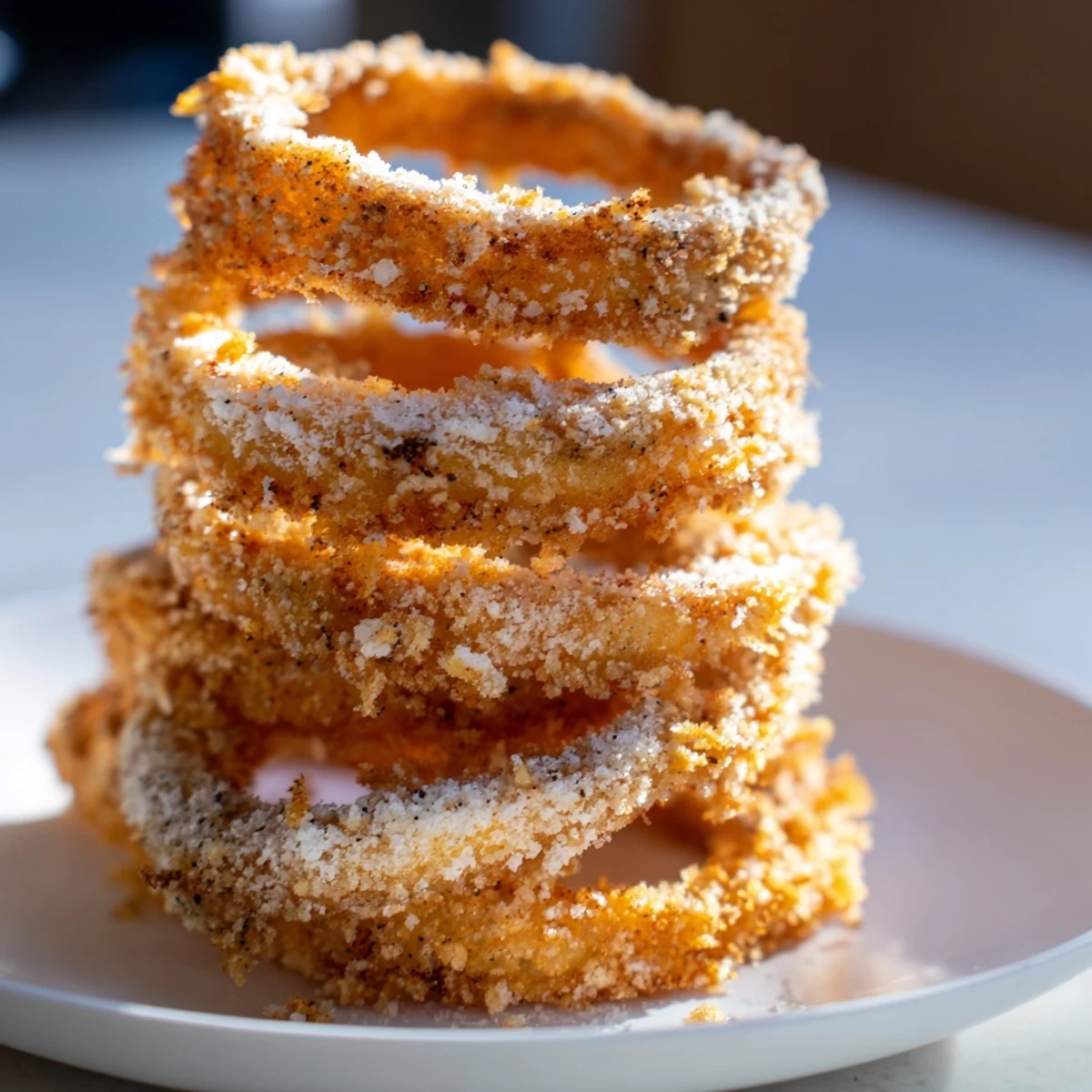 Close-up of golden, perfectly-cooked crispy onion rings, ready to be served hot.