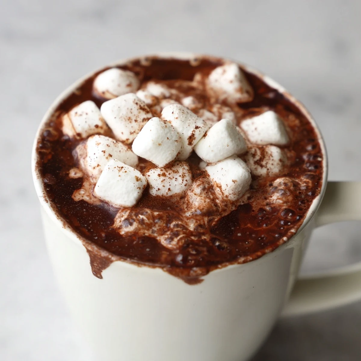 Fluffy marshmallows float on top of a dark, decadent Spiced Hot Chocolate, ready to enjoy.