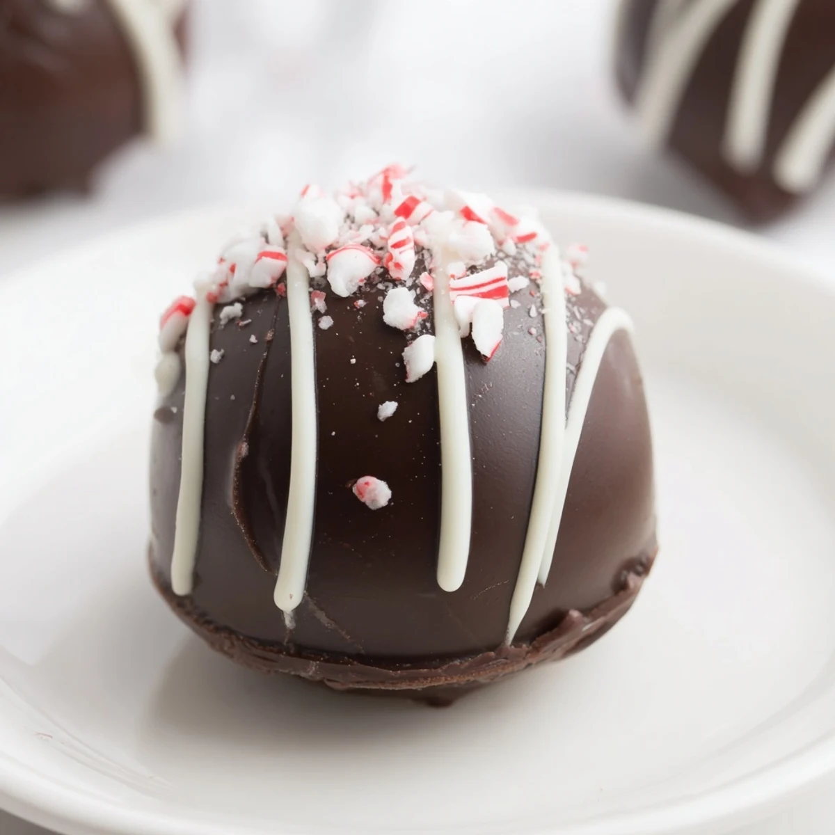 Rich, dark chocolate Peppermint Hot Cocoa Bombs melting into a creamy, festive, mint-infused hot chocolate drink.