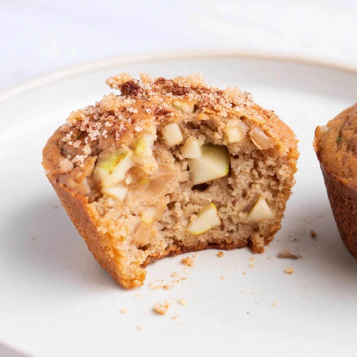 Fluffy homemade Apple Muffins, with visible apple chunks, perfect for a cozy morning treat.