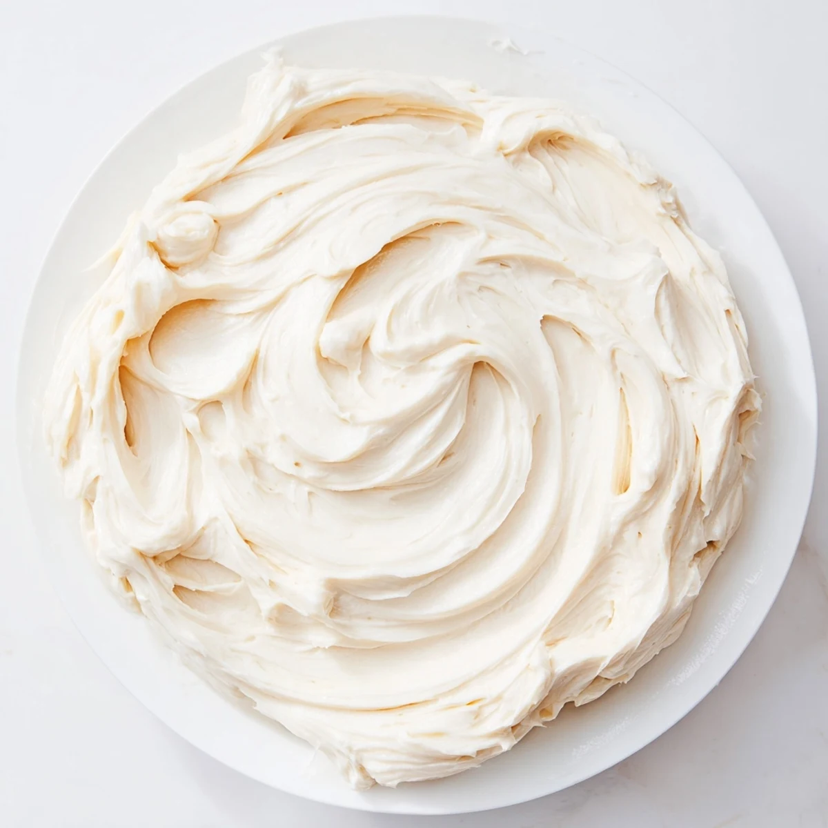 The creamy, smooth texture of fresh buttercream frosting, ideal for spreading or piping on your desserts.