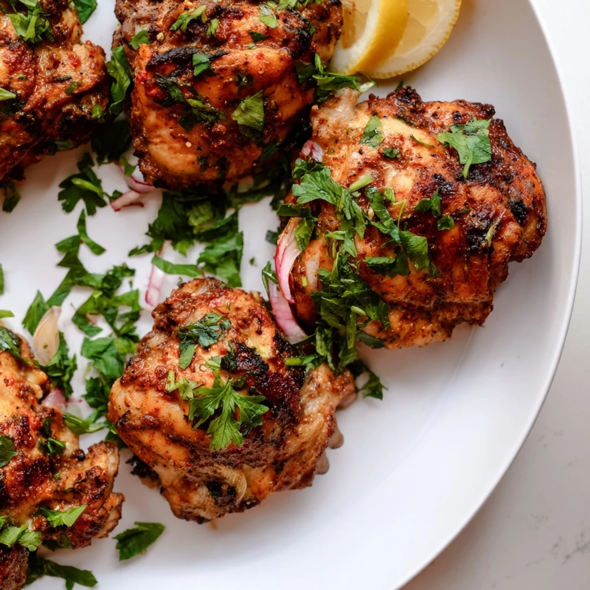 Golden-brown Aroma Spiced Chicken, cooked to perfection, garnished with fresh cilantro and red onion.