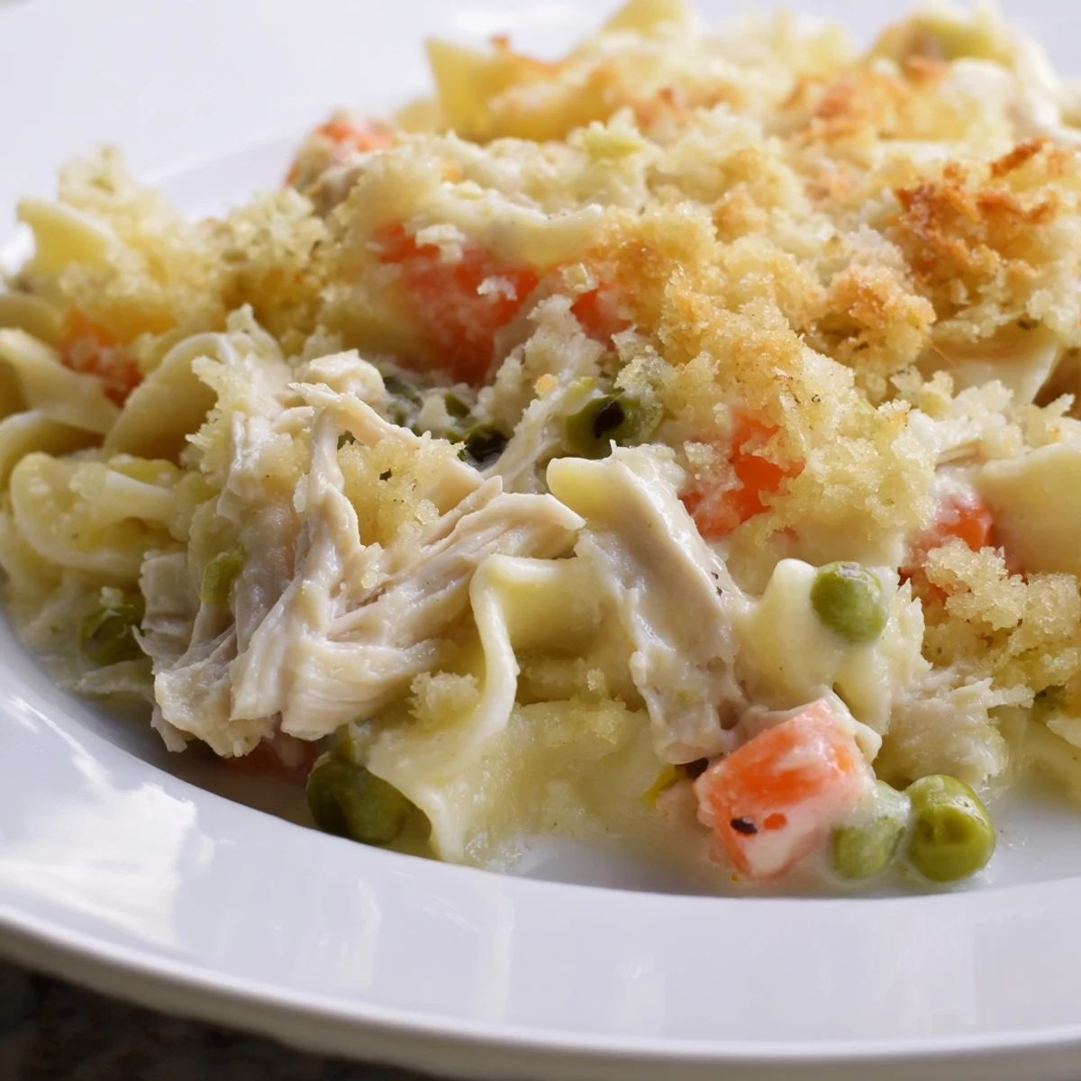 A close-up shot of a creamy Chicken Noodle Casserole showing its tender chicken and pasta layers.
