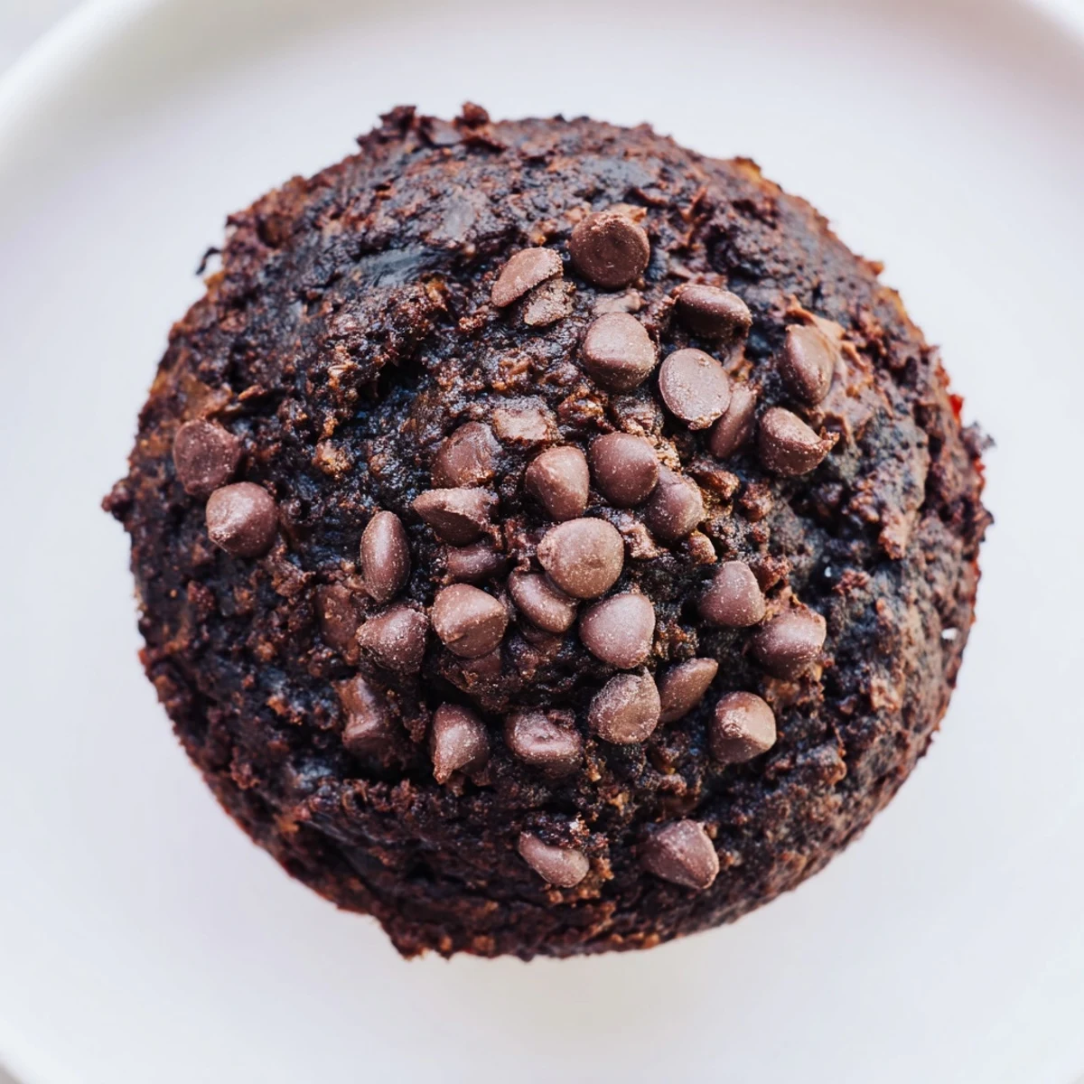 Homemade Chocolate Banana Muffins served with a glass of cold milk on the side.