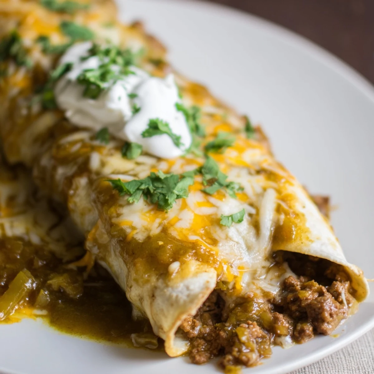 Freshly baked Beef Enchiladas with Green Chili Sauce served with sour cream on the side.