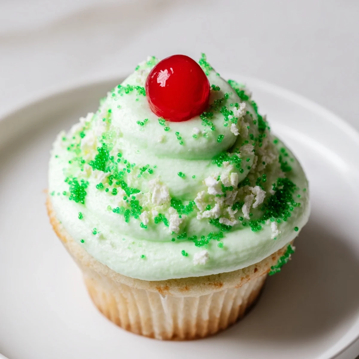 Indulgent Shamrock Shake Cupcakes served on a dessert plate, garnished with green sprinkles for a festive St. Patrick's Day treat.