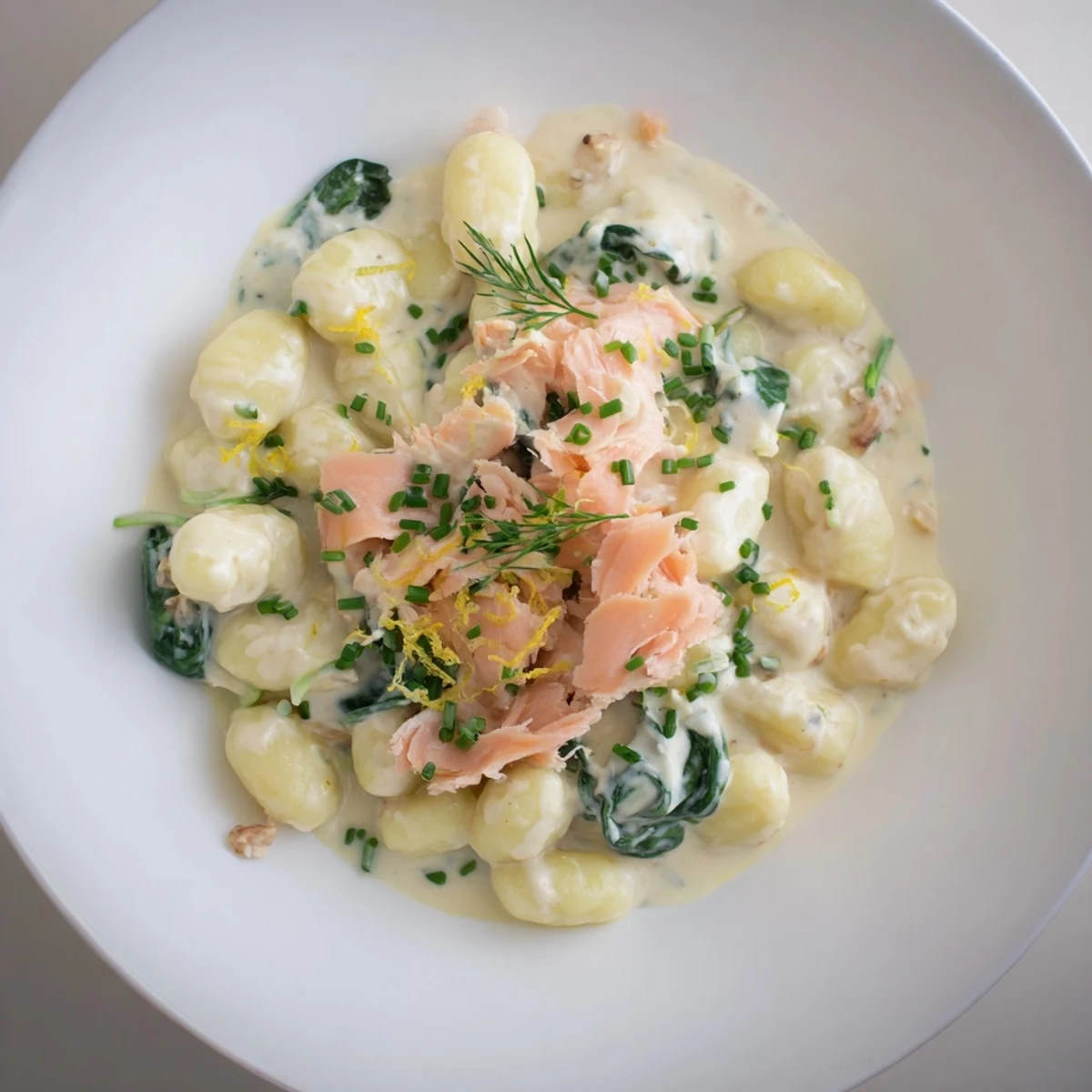 Creamy Healthy Smoked Salmon Gnocchi with fresh dill and lemon wedges.