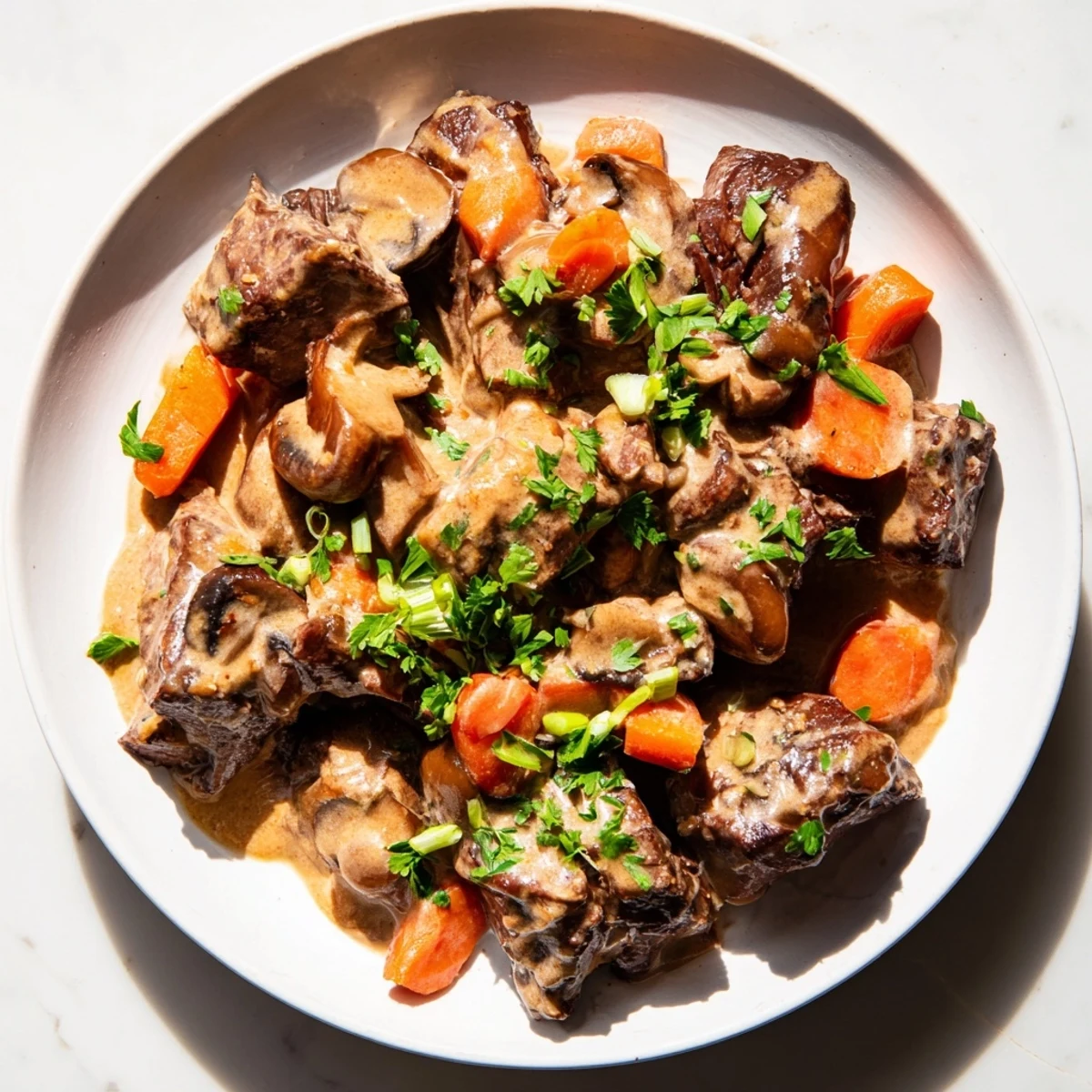 Close-up of Lemongrass Coconut Braised Beef with Mushrooms garnished with cilantro and lime wedges on a rustic plate.