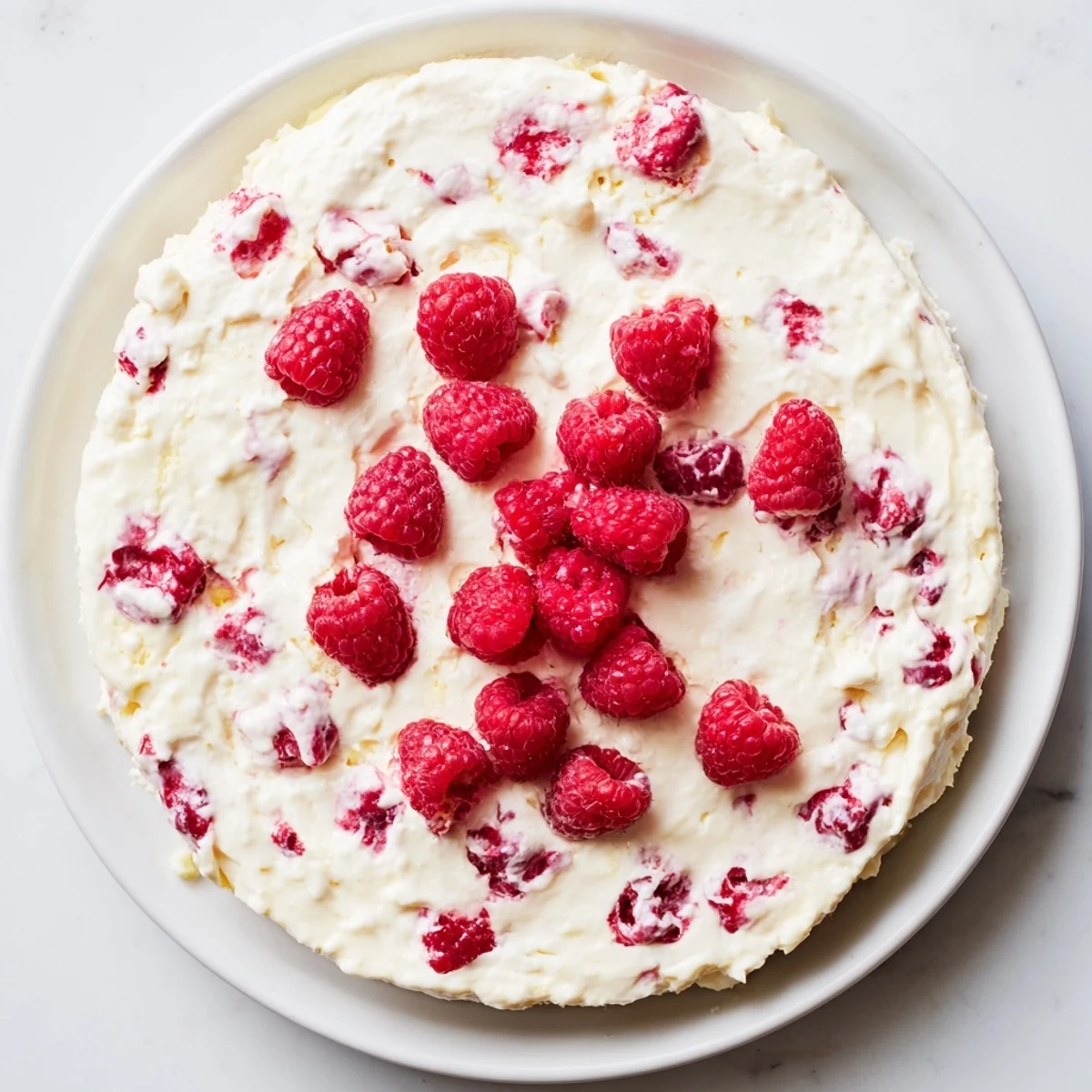 A slice of the Lemon Raspberry Cottage Cheese Bake shows creamy texture with fresh berry topping.