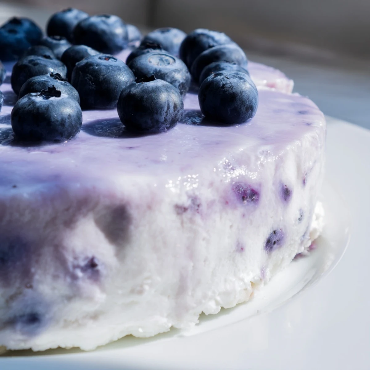 Freshly baked Blueberry Mousse Cheesecake with a creamy filling and vibrant blueberry topping on a marble counter.