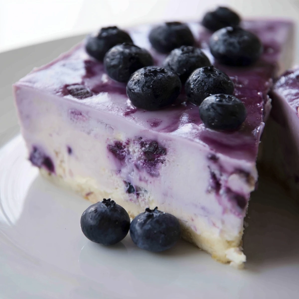 Sliced Blueberry Mousse Cheesecake reveals a smooth texture and juicy berries, perfect for summer gatherings.
