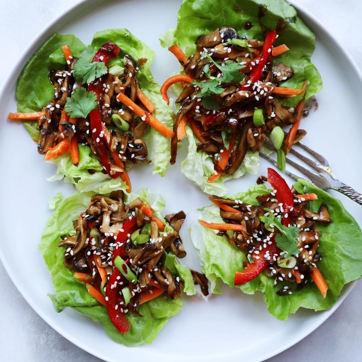 Freshly sautéed Shiitake Mushroom Lettuce Wraps served with toasted sesame seeds and cilantro garnish.