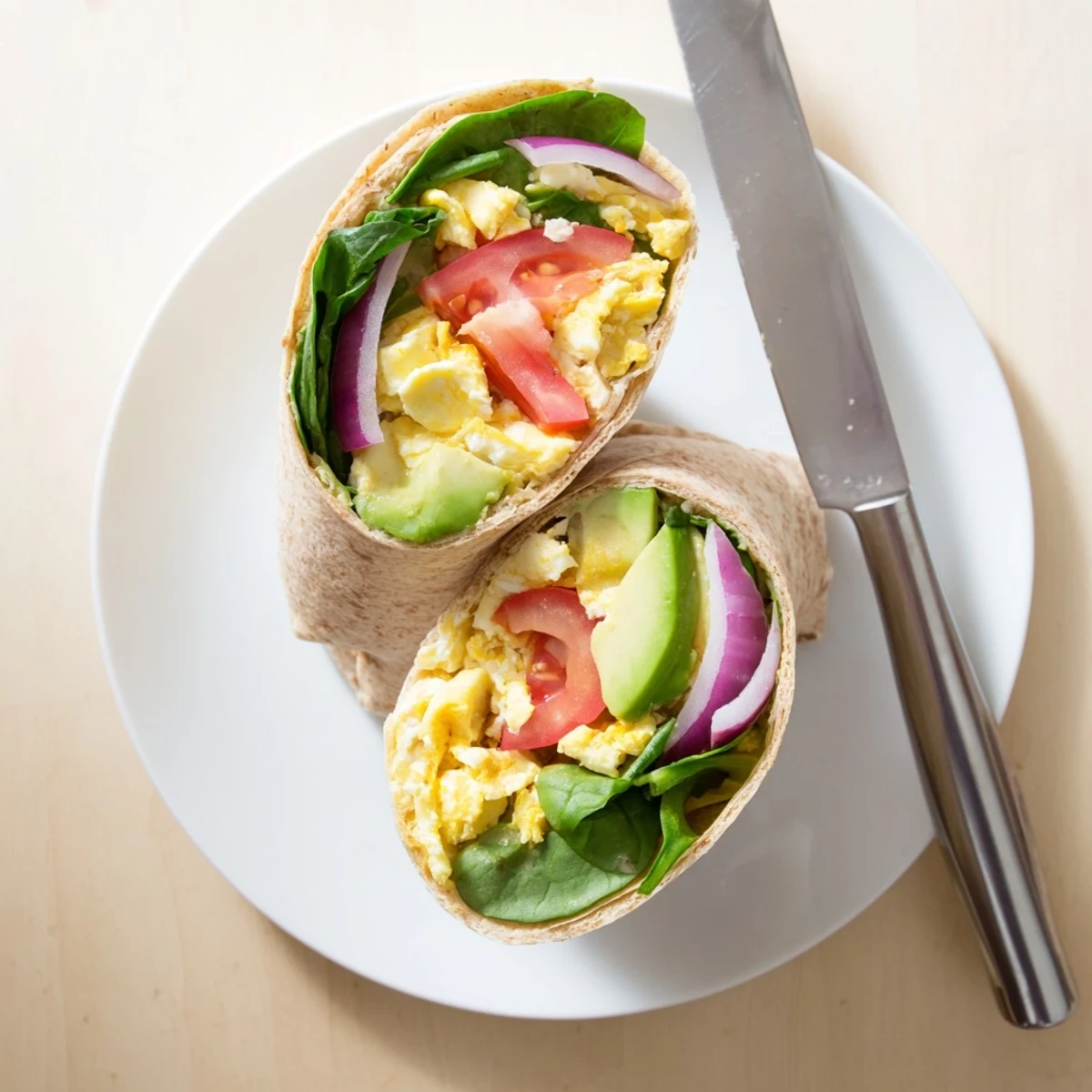 Fresh spinach and diced tomatoes top the High Protein Breakfast Wrap, with a dollop of cottage cheese and hot sauce.