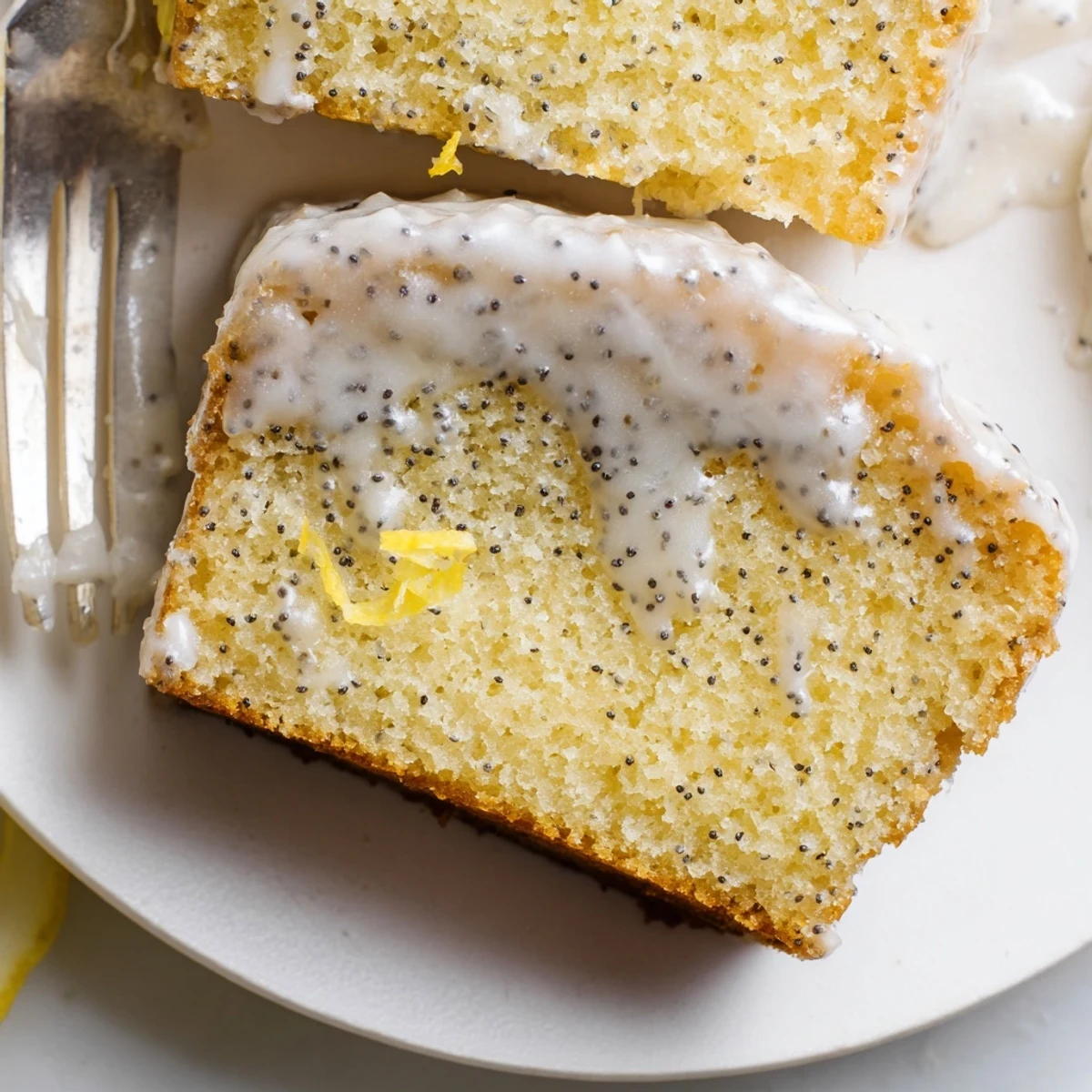 Golden Lemon Poppy Seed Cake rests on a cooling rack with a drizzle of citrus glaze.