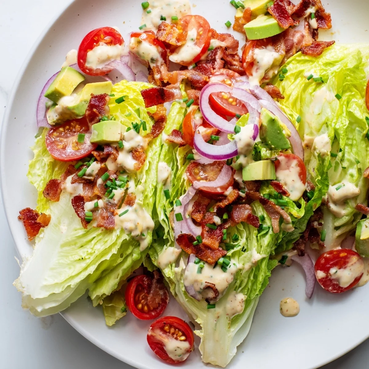 A fresh bowl of Crispy Bacon Keto BLT Salad features juicy tomatoes and crumbled bacon.