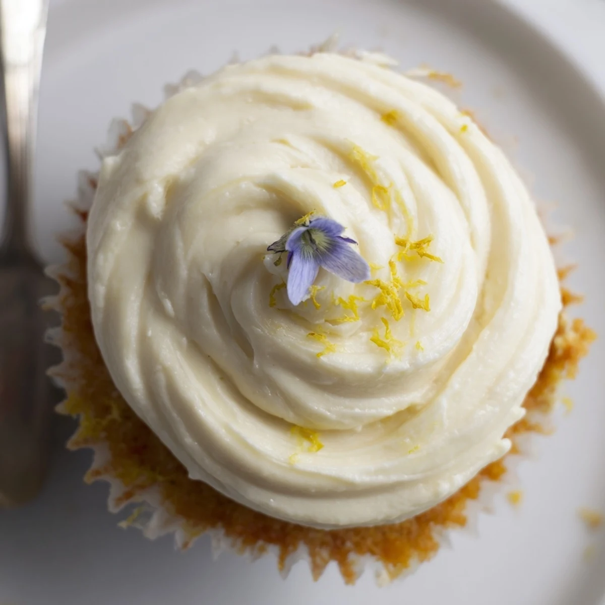 Moist Elderflower Cupcakes on a wire rack, brushed with syrup and topped with fluffy frosting, ready to serve with Earl Grey tea.