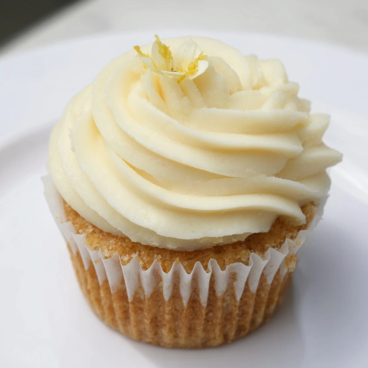 A close-up of Elderflower Cupcakes with creamy buttercream swirls and delicate edible flowers, perfect for a spring tea party.