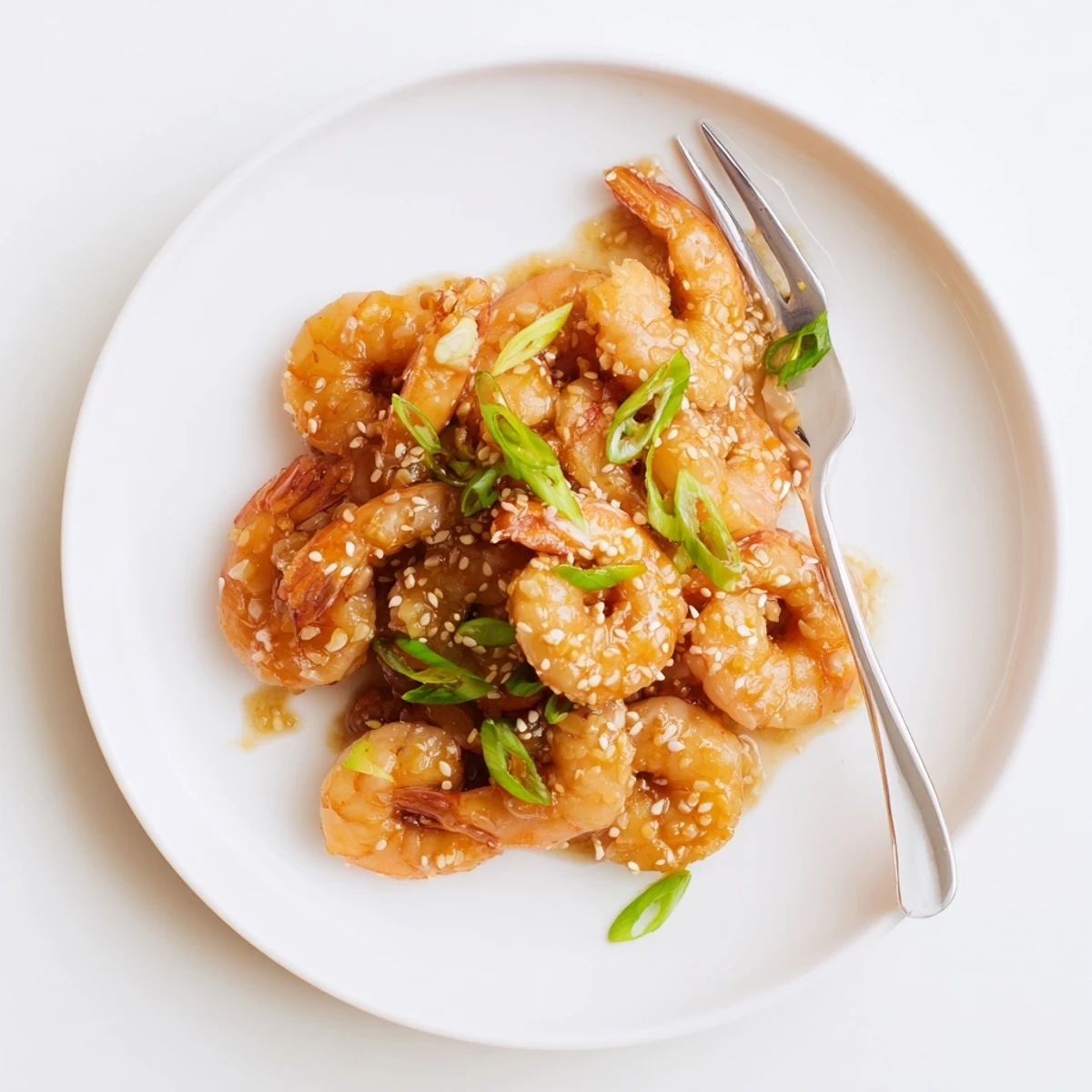 A skillet of High Protein Honey Garlic Shrimp with steamed broccoli and drizzled honey garlic sauce.
