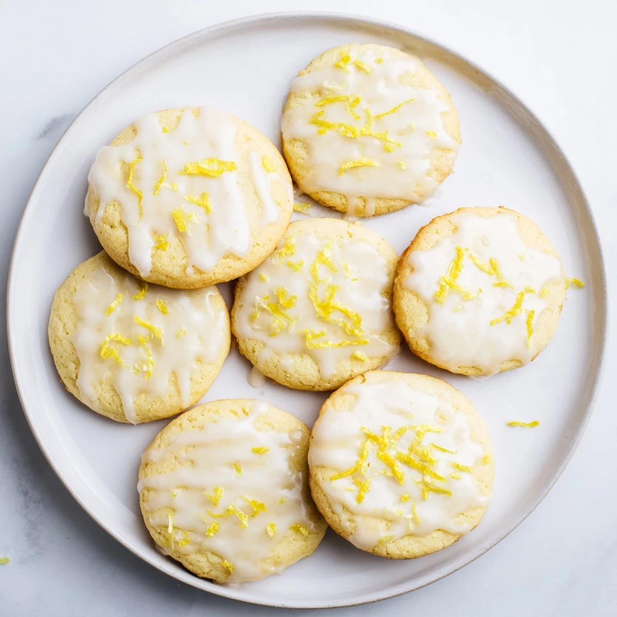 A plate of Limoncello cookies shows soft centers, crisp edges, and drizzled glaze, ideal for summer dessert platters.