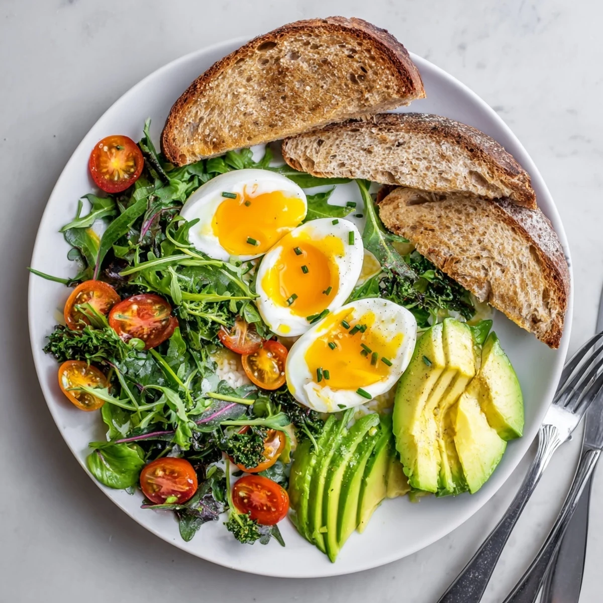 Ready-to-eat Savory Breakfast Plate featuring halved soft eggs, crisp artisan toast, and a colorful medley of greens and herbs.