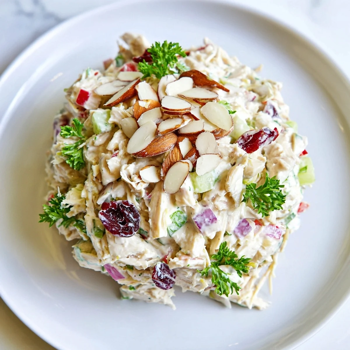 Creamy Greek yogurt rotisserie chicken salad with crisp red bell pepper and celery pieces on a white plate