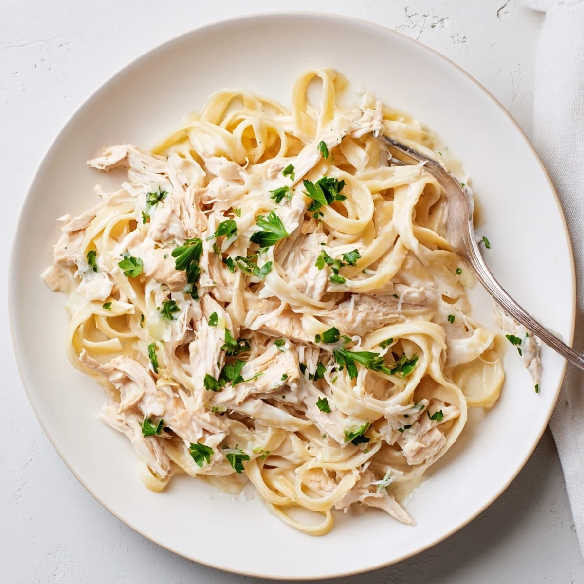 Creamy Crock Pot Chicken Alfredo with tender shredded chicken and al dente fettuccine in rich Parmesan sauce