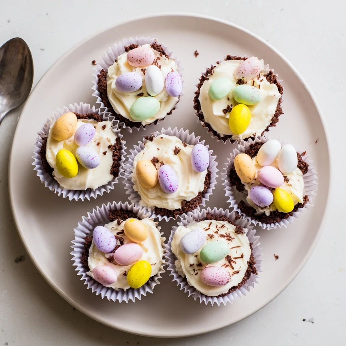 Golden Easter Cadbury Mini Cheesecakes with colorful Mini Egg toppings on chocolate cookie crust