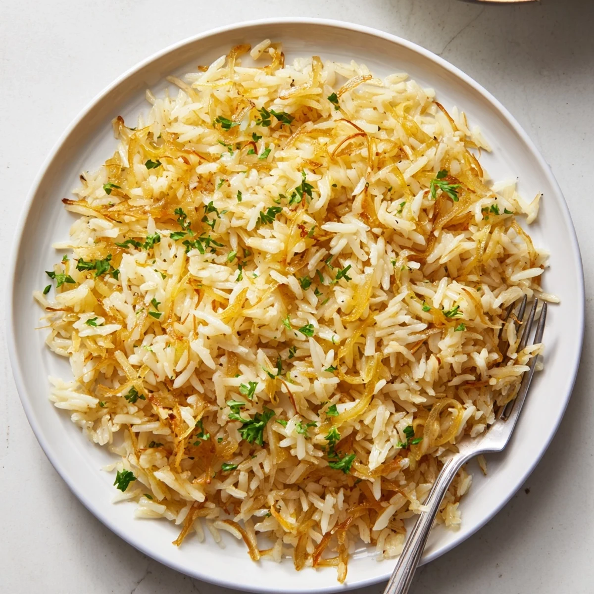 Golden French onion butter rice topped with fresh parsley and melted Gruyère cheese