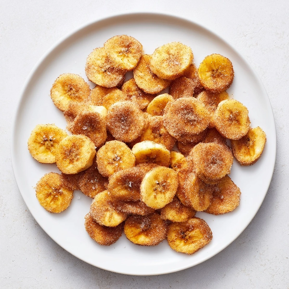 Homemade air fryer banana chips sprinkled with cinnamon and sugar for healthy snacking