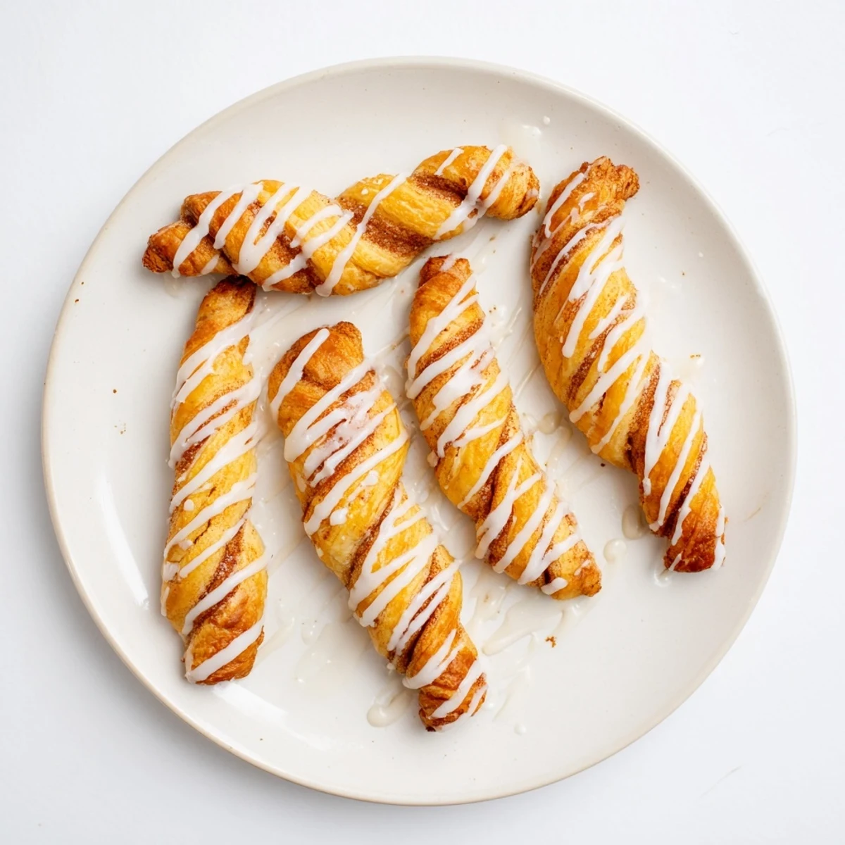 Soft baked pastry twists spiraled with brown cinnamon sugar and finished with sweet icing