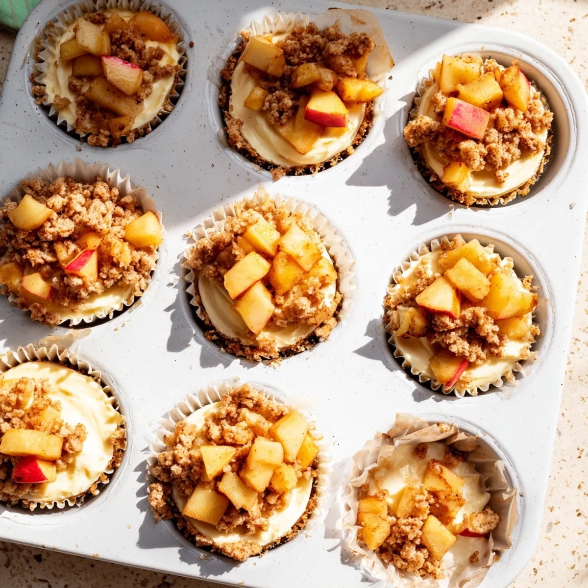 Rich cheesecake bites featuring crunchy oat streusel and sweet diced apples on a pressed graham cracker base