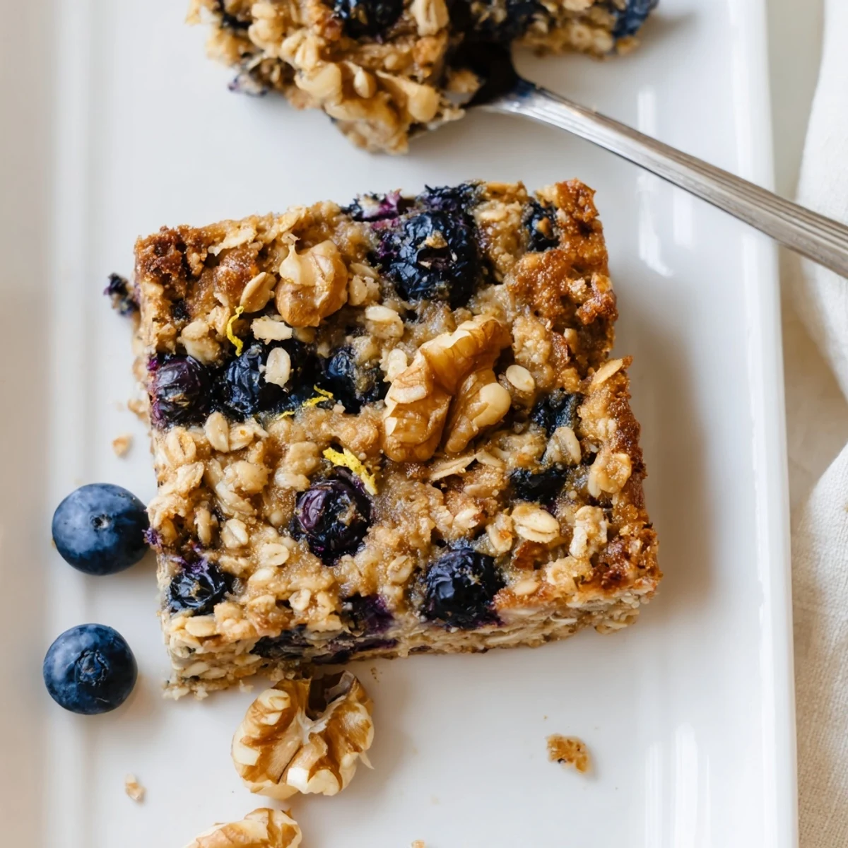 Golden baked lemon blueberry oatmeal with juicy berries bursting throughout a wholesome breakfast dish