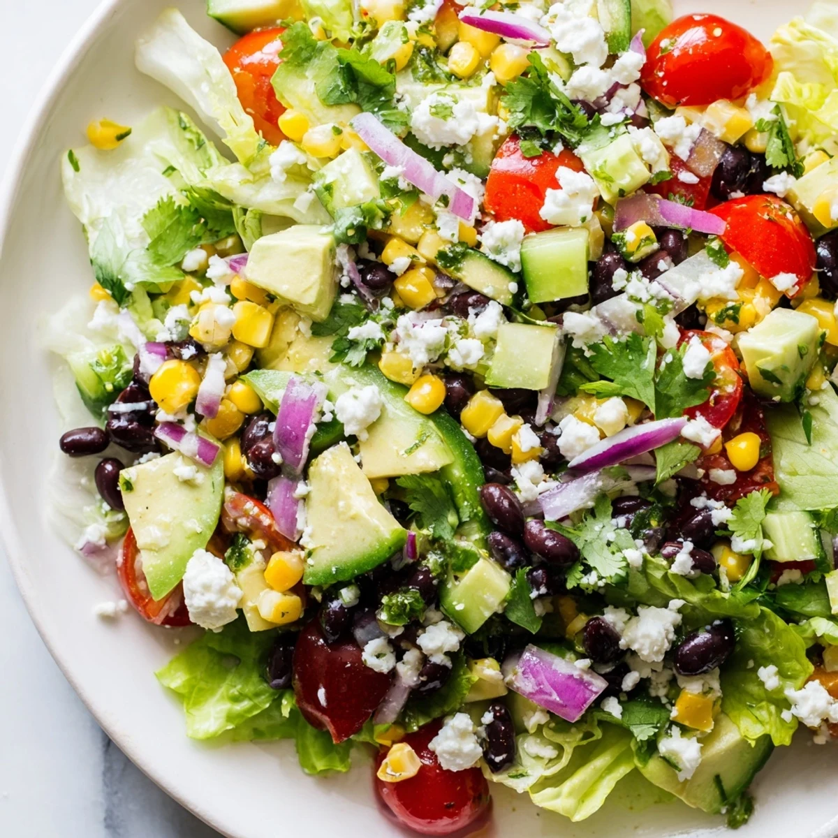 Fresh Mexican chopped salad featuring ripe avocado, black beans, and crisp vegetables in zesty lime dressing