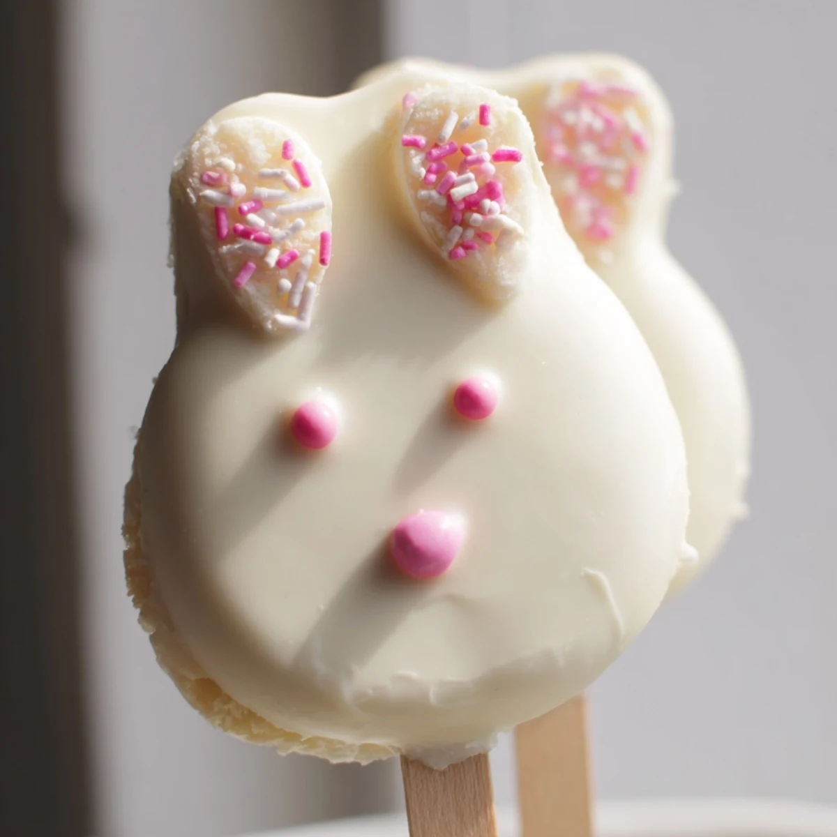 Creamy white chocolate bunny cakesicles decorated with sprinkles for festive Easter celebrations