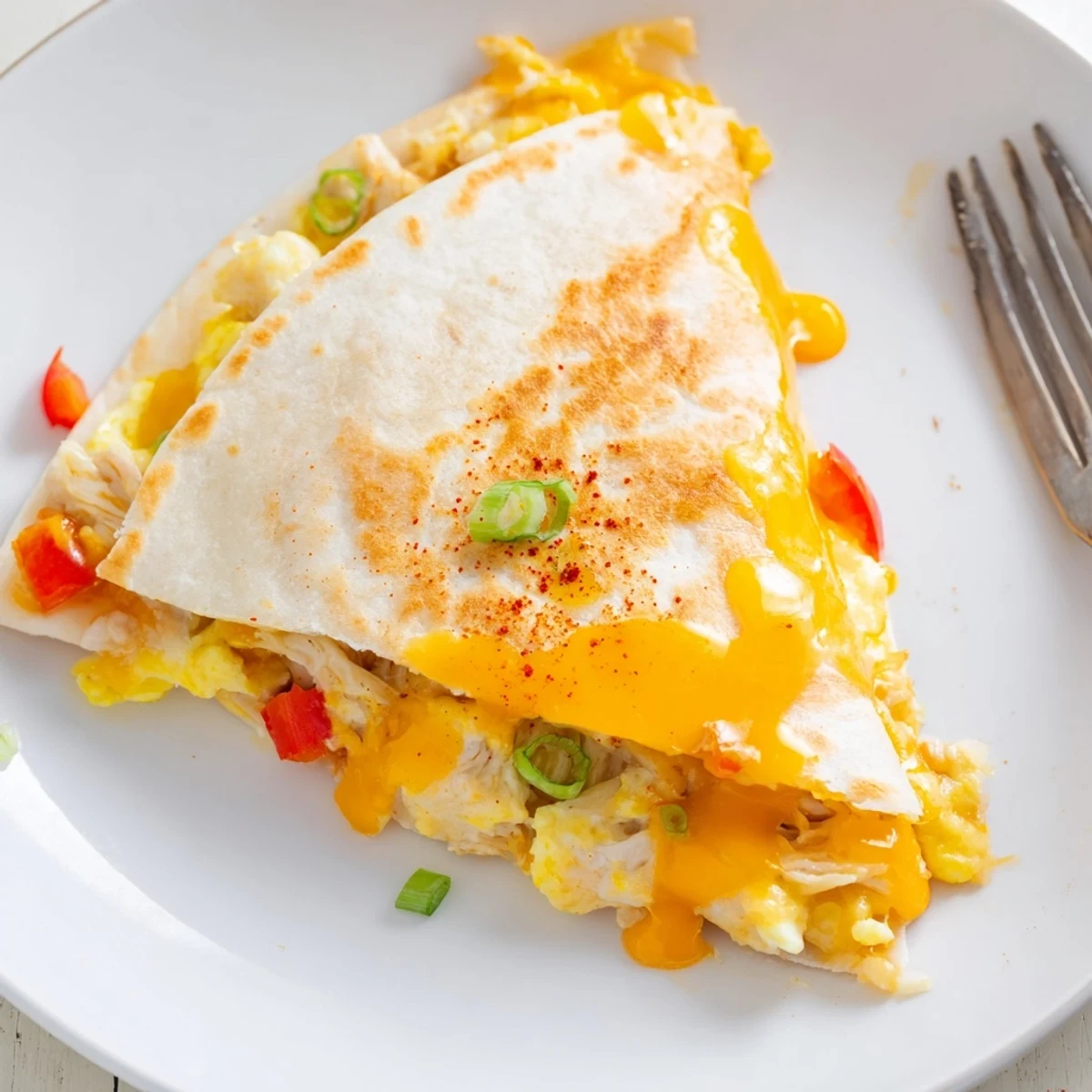 Skillet toasted Chicken Breakfast Quesadilla oozing cheddar, tender chicken, and bell pepper