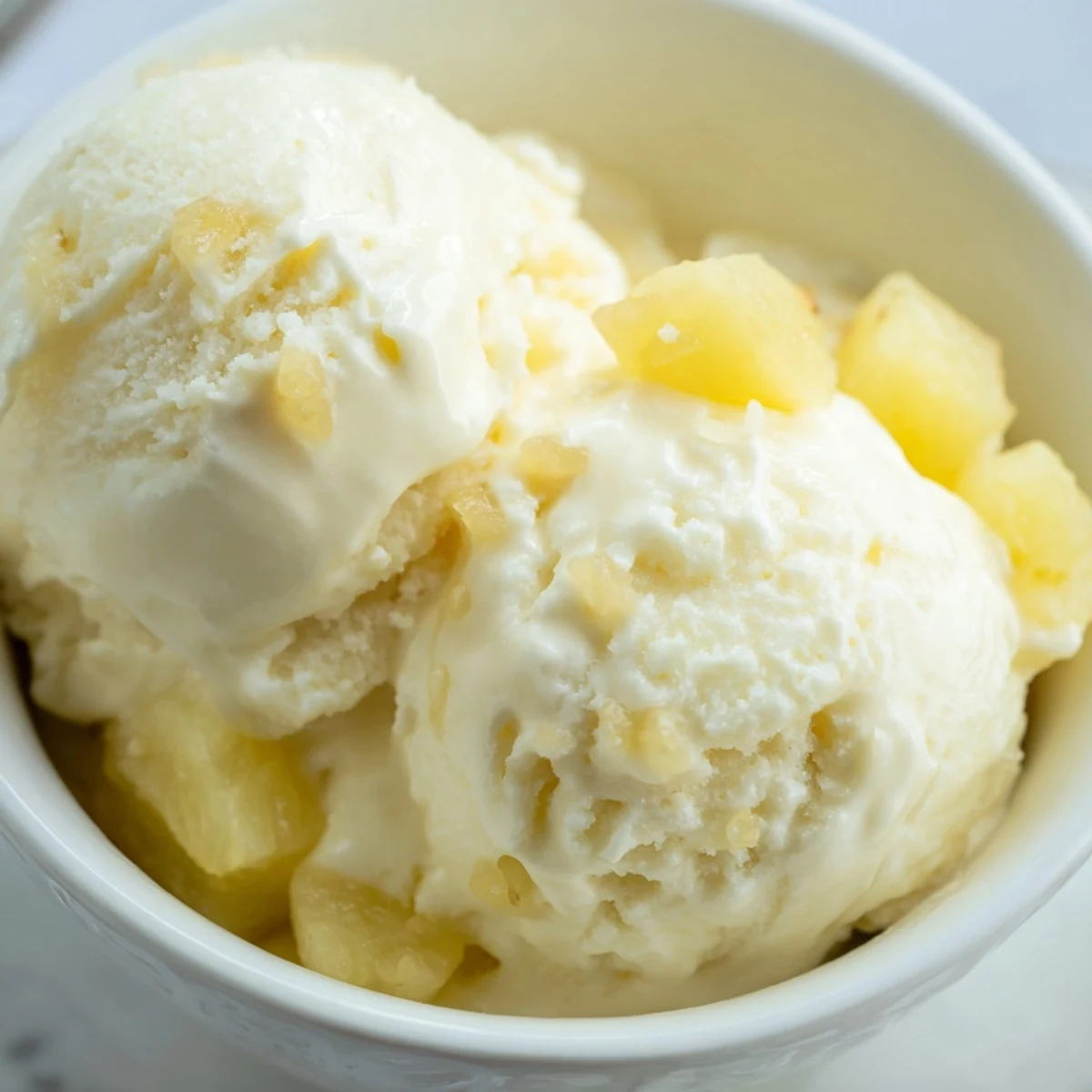Creamy Pineapple Ice Cream served in bowl, glossy churned texture, tropical aroma
