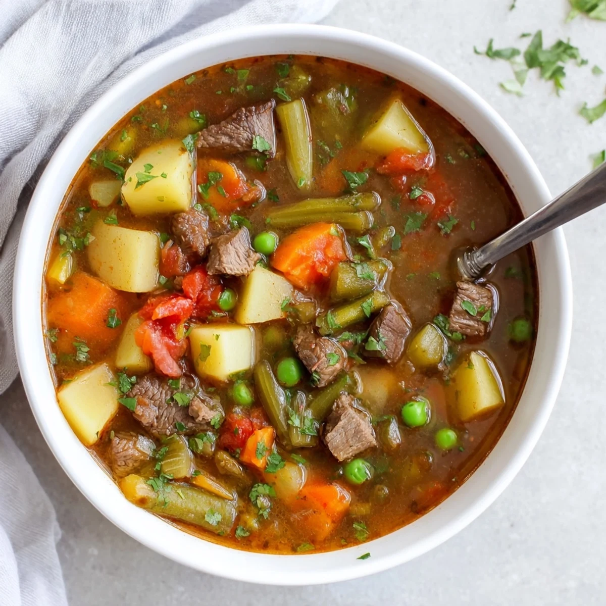 Rustic braised vegetable beef soup featuring tender beef chunks with carrots potatoes and celery in rich broth