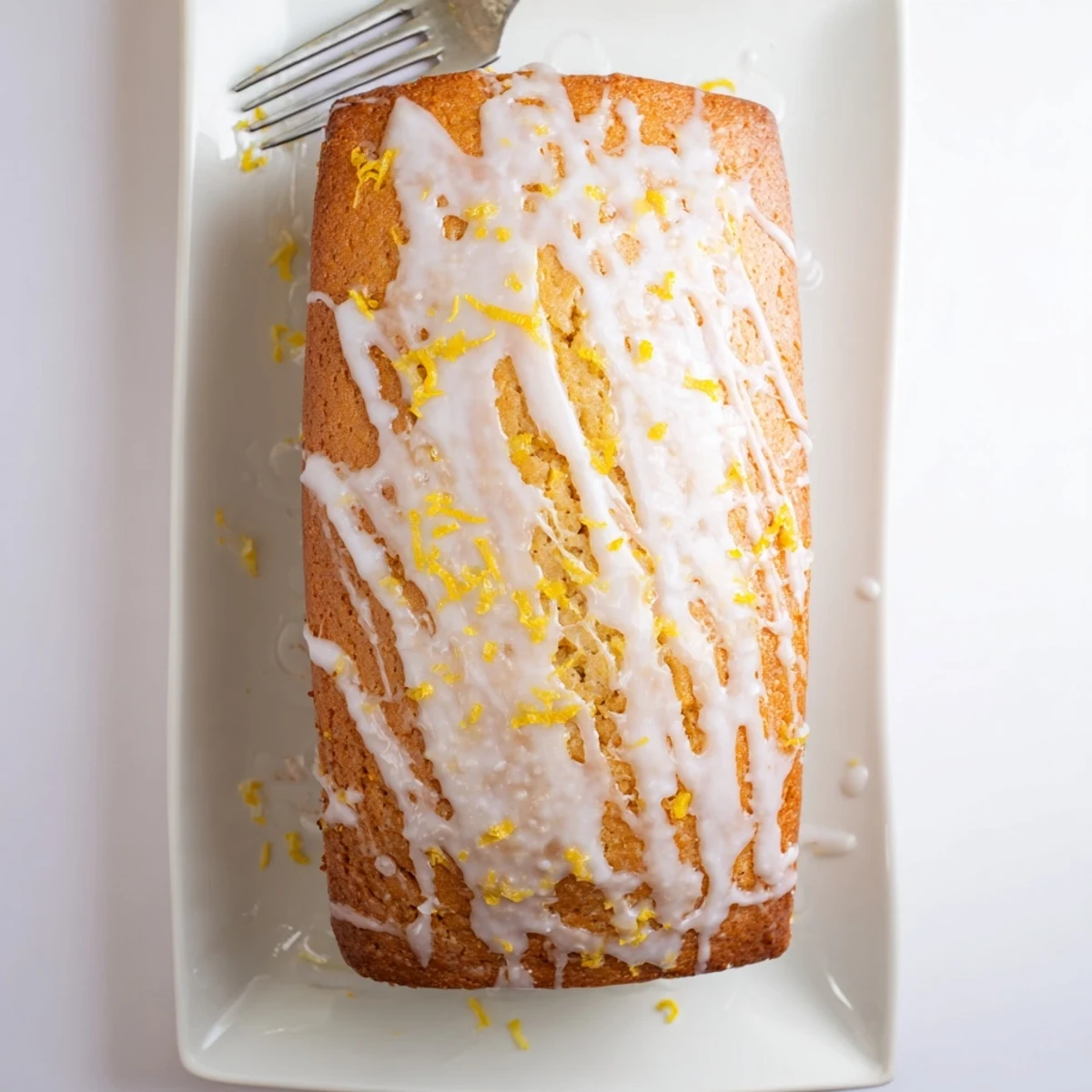 Tangy Greek yogurt lemon bread cooling on wire rack with citrus zest garnish