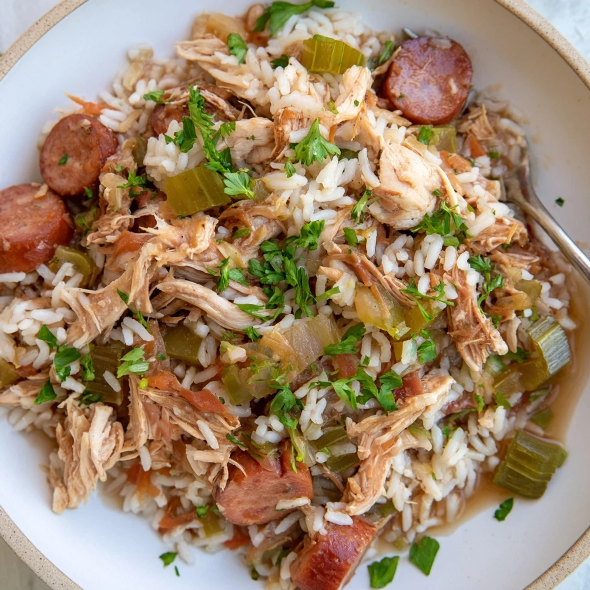 Golden Chicken Bog featuring tender shredded chicken, smoked sausage, and fluffy seasoned rice in a rustic serving bowl