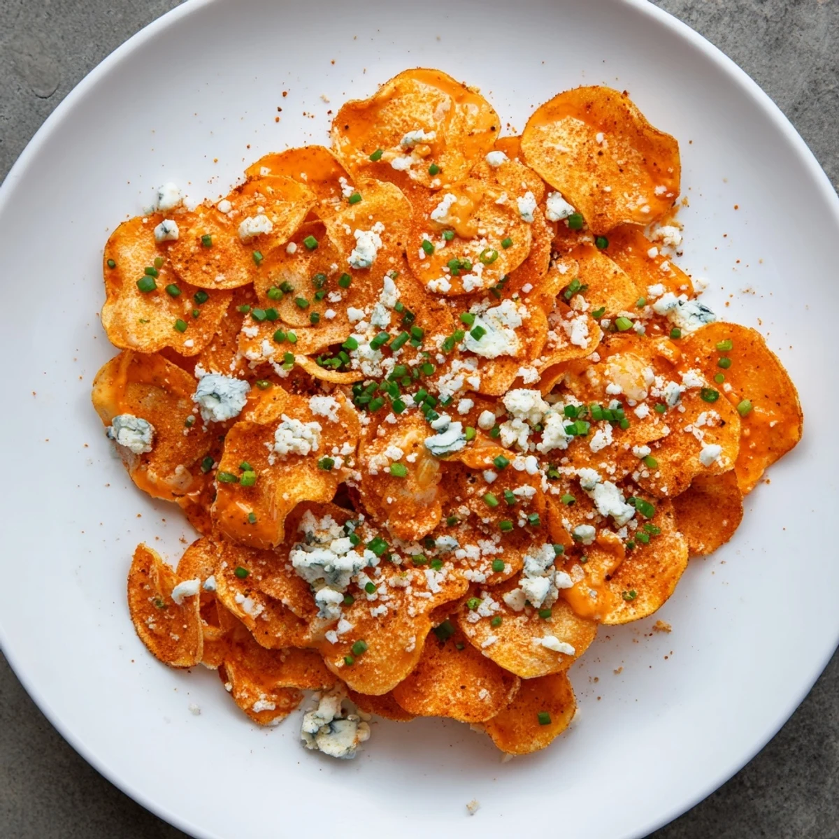 Golden crispy Buffalo chips tossed in spicy red sauce and topped with crumbled blue cheese