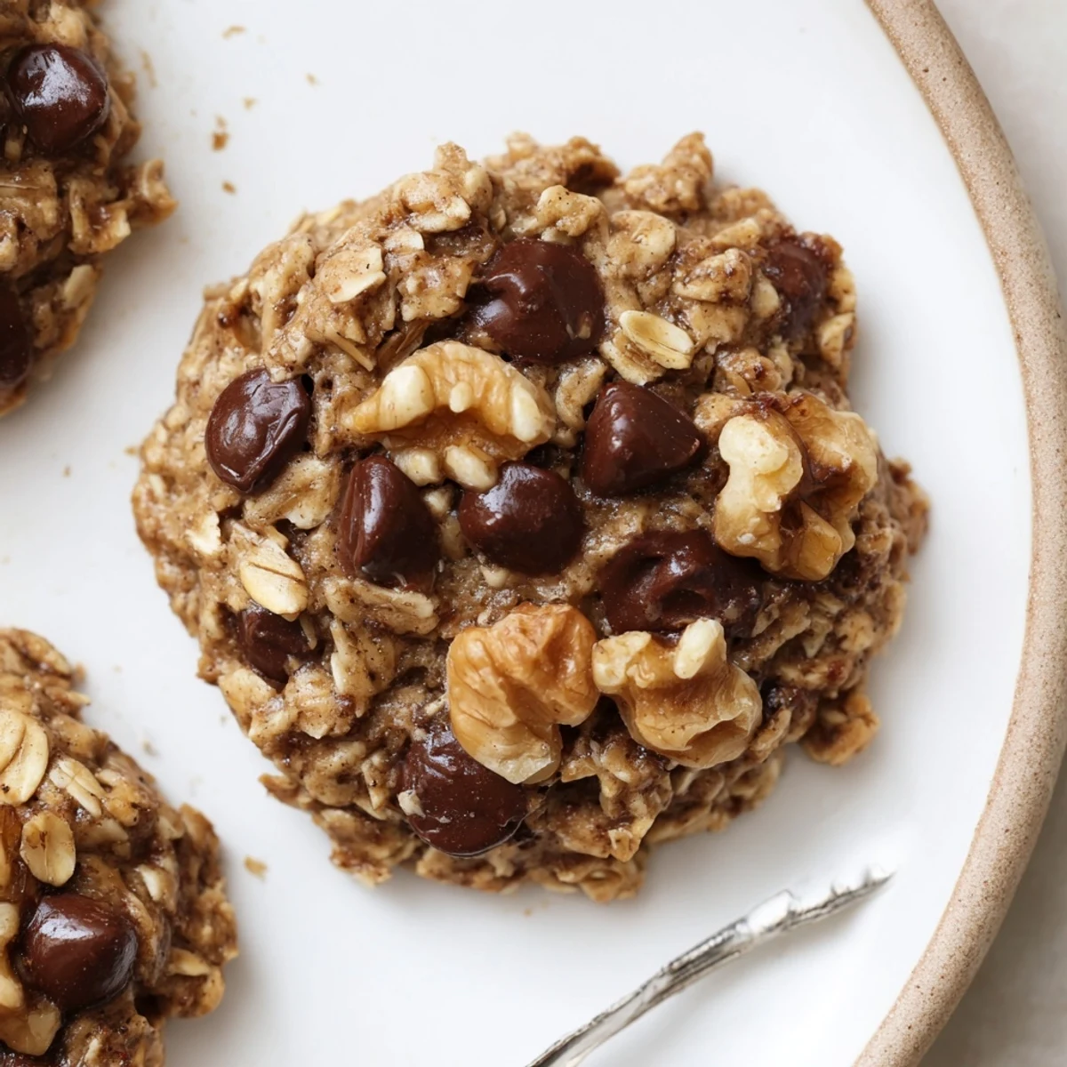 Homestyle Banana Oat Cookies stacked beside a glass of almond milk.
