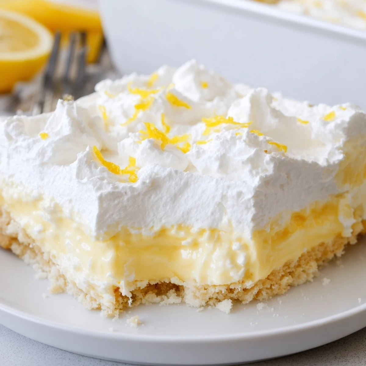 Creamy Lemon Lush Cake with whipped topping and bright lemon zest