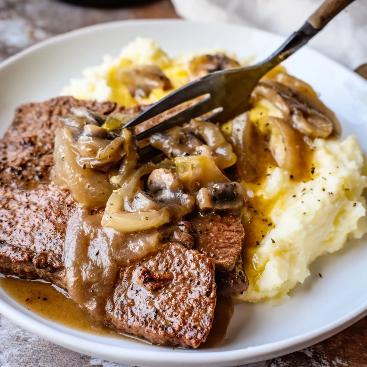 Country Style Smothered Cube Steak Recipe in onion mushroom gravy over mashed potatoes