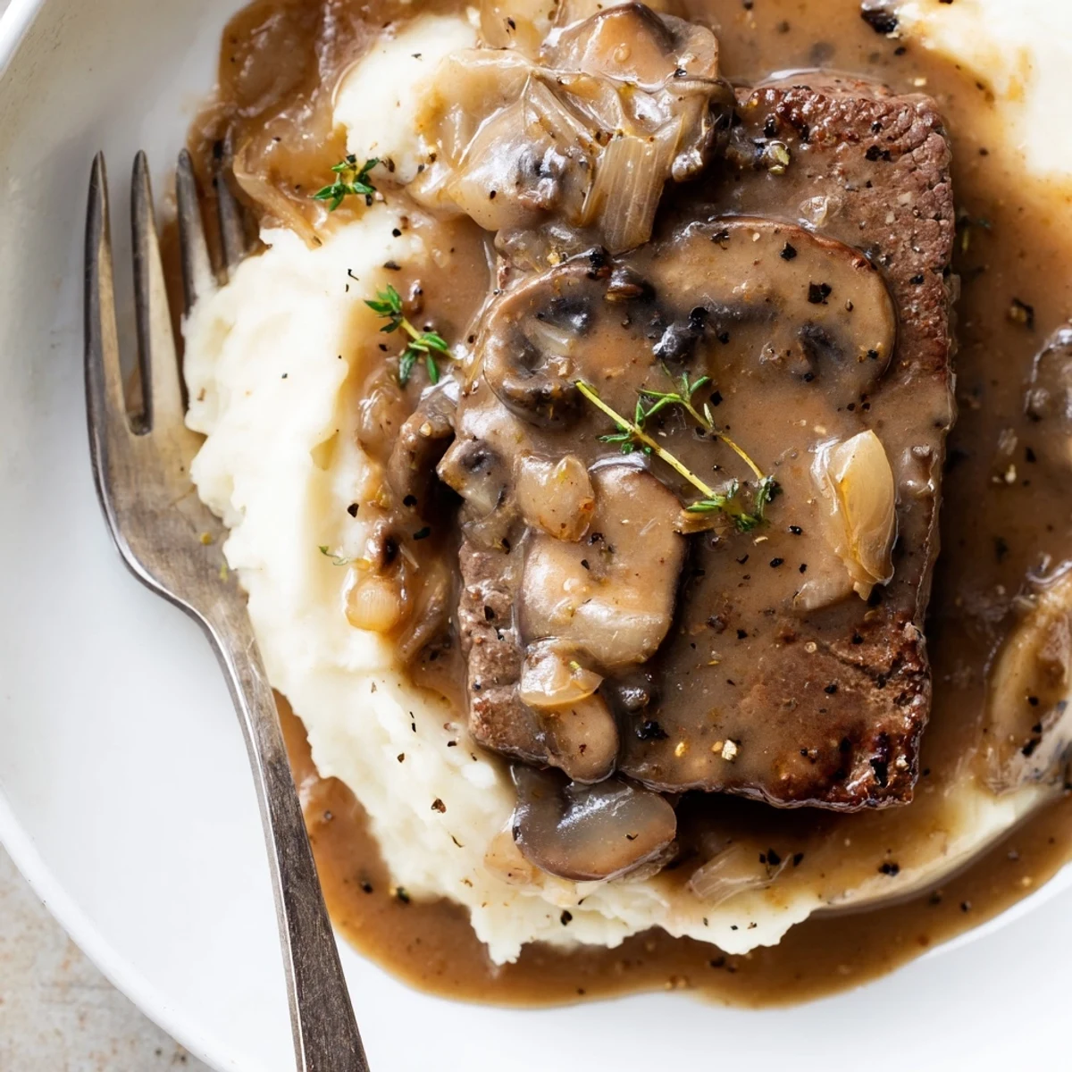 Weeknight Country Style Smothered Cube Steak Recipe plated with creamy mashed potatoes and gravy