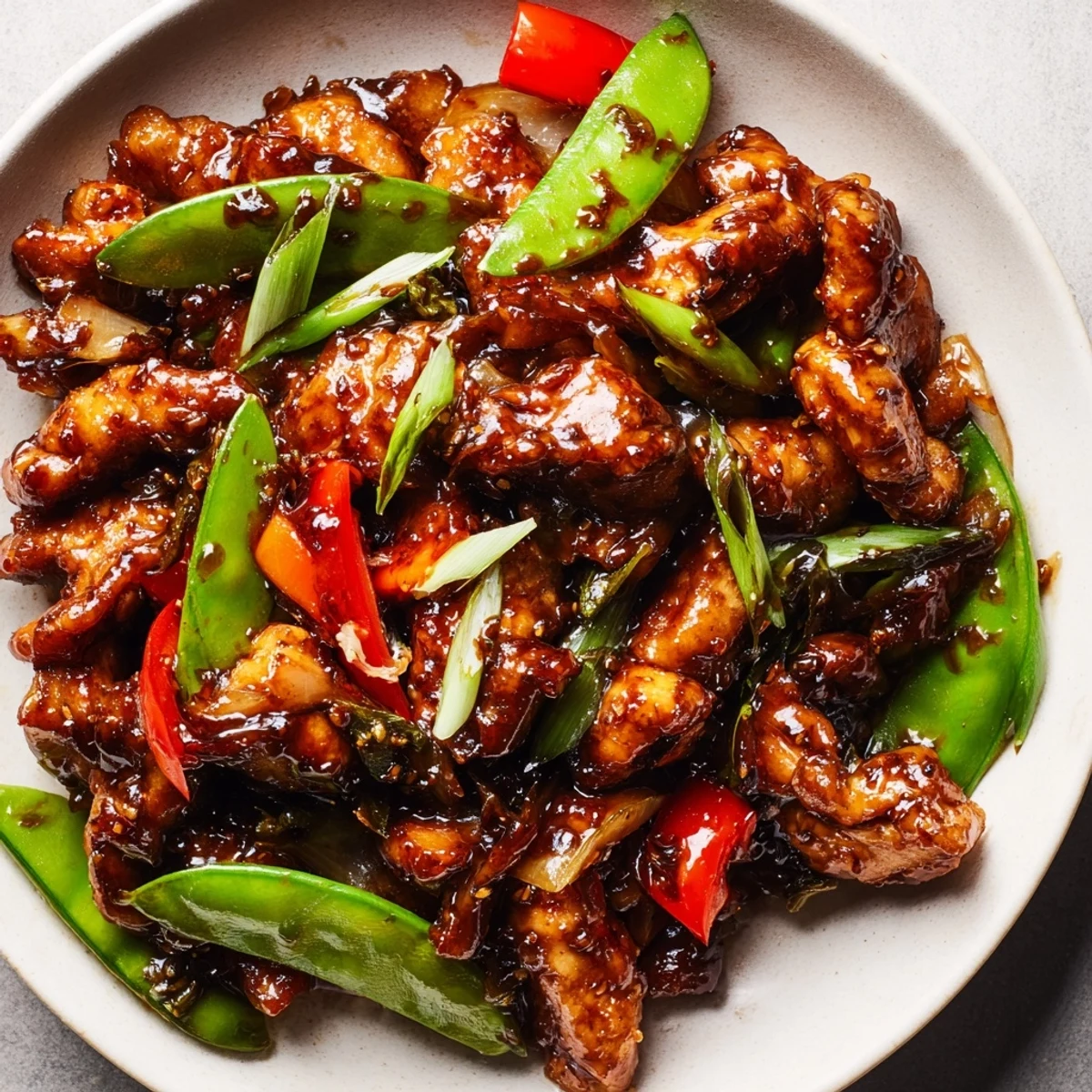 Tender stir fried Chinese garlic chicken tossed with vibrant vegetables in a wok