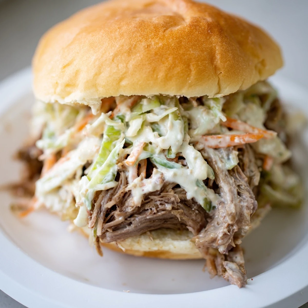 Crisp coleslaw and tender Alabama white sauce pulled lamb piled high on mini buns