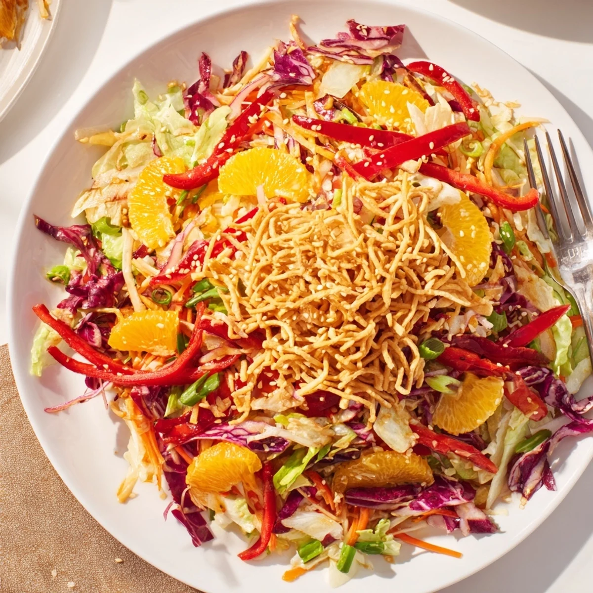 Crisp Mandarin Sesame Crunch Salad topped with golden noodles and vibrant vegetables