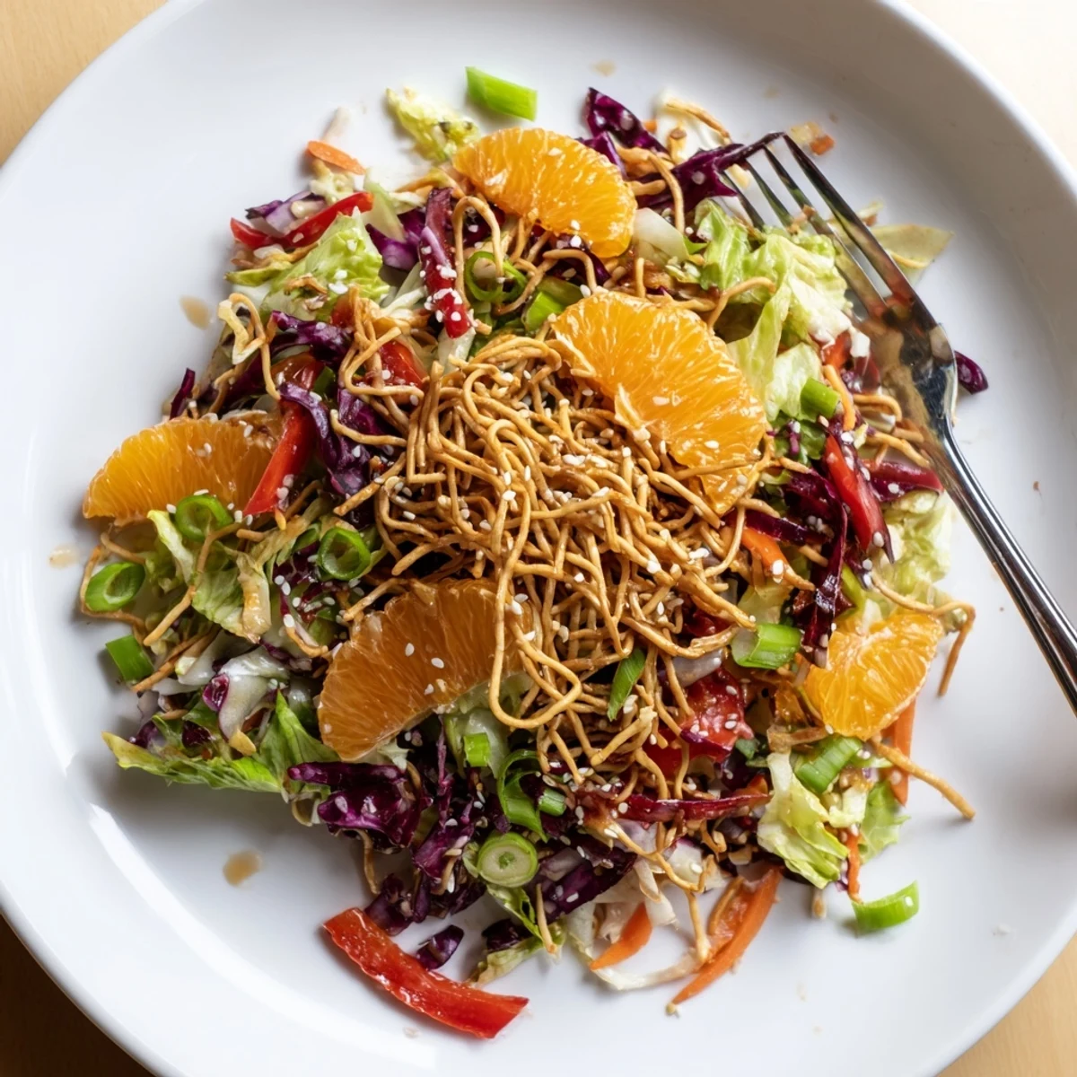 Mandarin Sesame Crunch Salad drizzled with tangy dressing on a rustic plate
